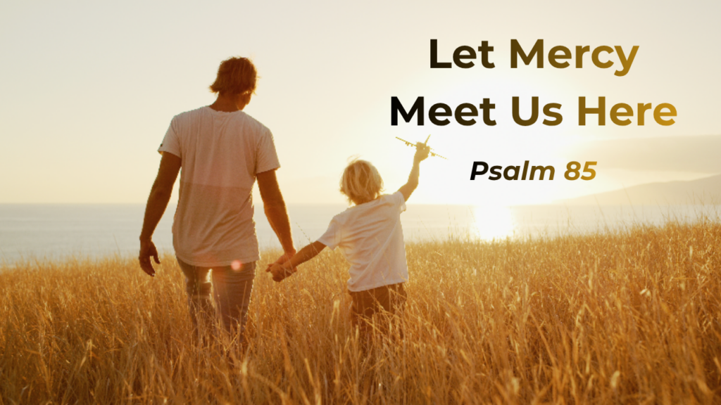 Father walking through field holding son's hand with text "Let mercy meet us here - Psalm 85"