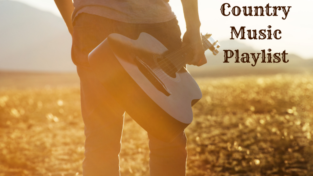 Man in jeans walking across golden field carrying a guitar with the text "Country Music Playlist"